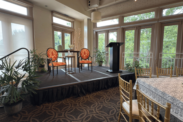 Business Meeting with Guest Speakers Business Meeting with Guest Speakers - A stage, podium, and comfortable seating to draw attention to your meeting's guest speakers.