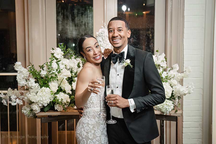 Megan & Aaron's Proximity Hotel Wedding | Photo by In His Image Photography Bride and Groom smiling as they toast to each other at their elegant black tie wedding reception in the Weaver Room.